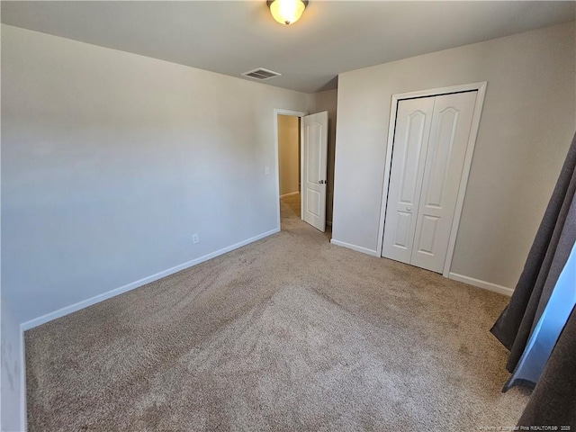 unfurnished bedroom featuring carpet, visible vents, a closet, and baseboards