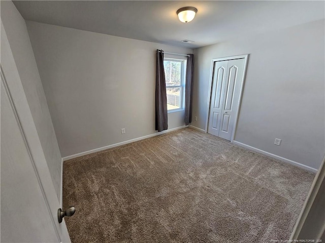 carpeted spare room featuring baseboards