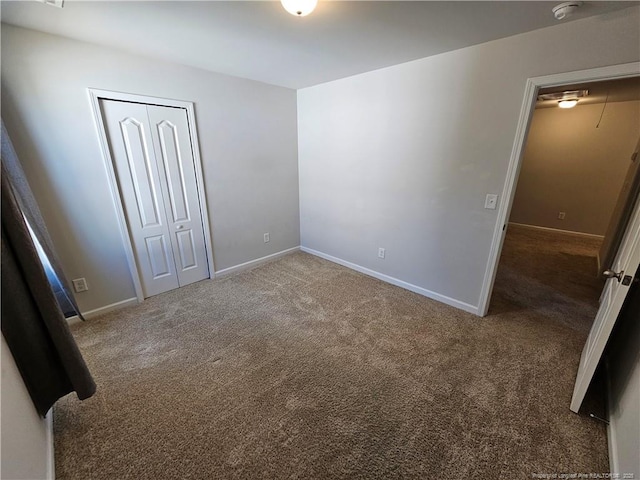 unfurnished bedroom with a closet, carpet flooring, and baseboards