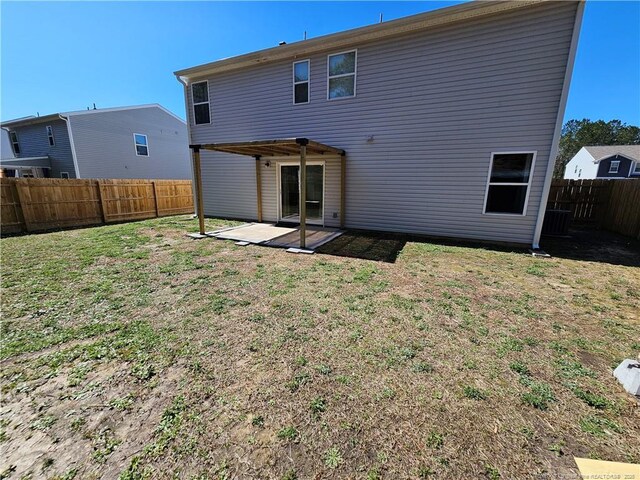 back of property with a yard, a patio, and a fenced backyard