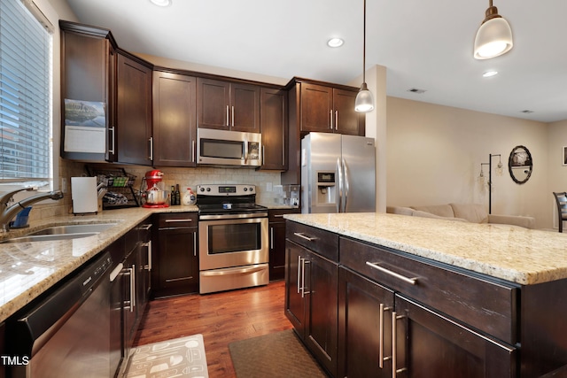 kitchen with a sink, stainless steel appliances, dark brown cabinetry, and dark wood finished floors