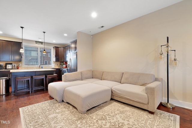 living area featuring recessed lighting, baseboards, and dark wood finished floors