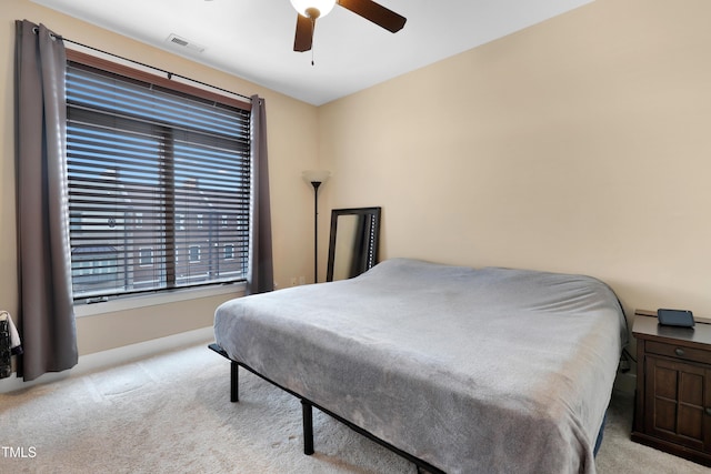 carpeted bedroom featuring a ceiling fan and visible vents