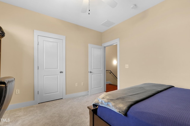 carpeted bedroom with visible vents, a ceiling fan, and baseboards