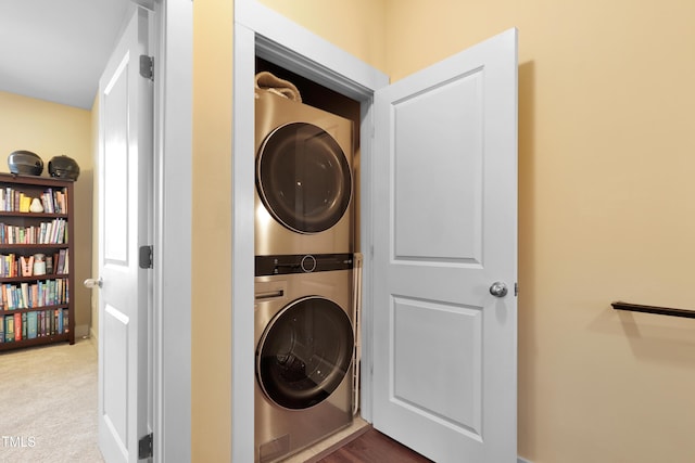 clothes washing area featuring laundry area, carpet, and stacked washing maching and dryer