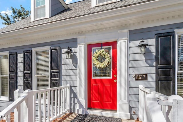 property entrance featuring a shingled roof