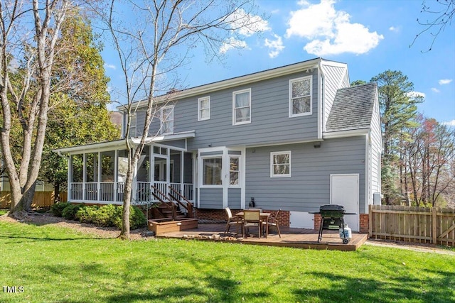 back of property featuring a lawn, a wooden deck, fence, and a sunroom