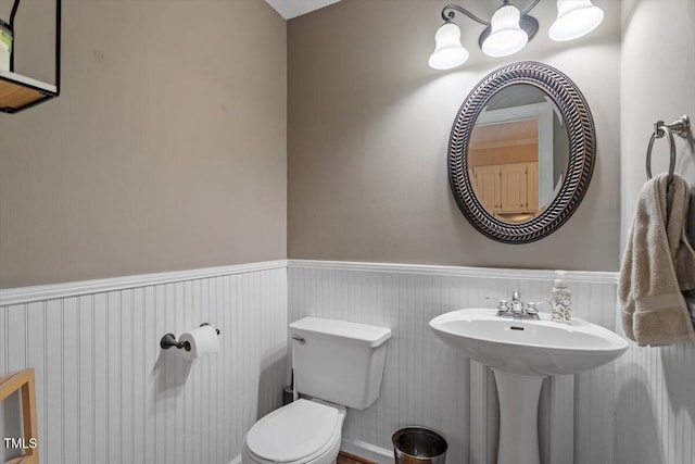 bathroom featuring a wainscoted wall and toilet