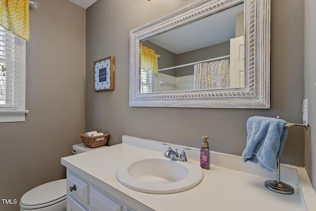 bathroom featuring toilet, vanity, and a shower with shower curtain