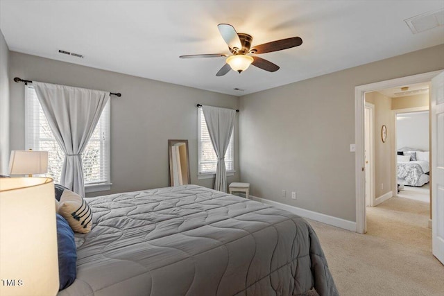 bedroom with light carpet, visible vents, multiple windows, and baseboards