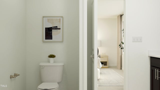 bathroom featuring vanity, toilet, and baseboards