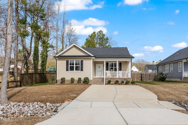 view of front of home featuring covered porch and fence