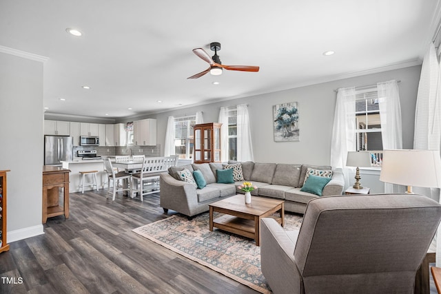 living area featuring a wealth of natural light, dark wood-style floors, ornamental molding, and recessed lighting