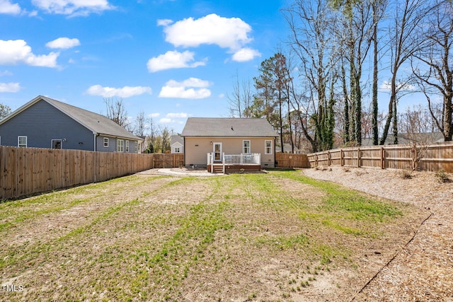 rear view of house with crawl space, a wooden deck, a lawn, and a fenced backyard