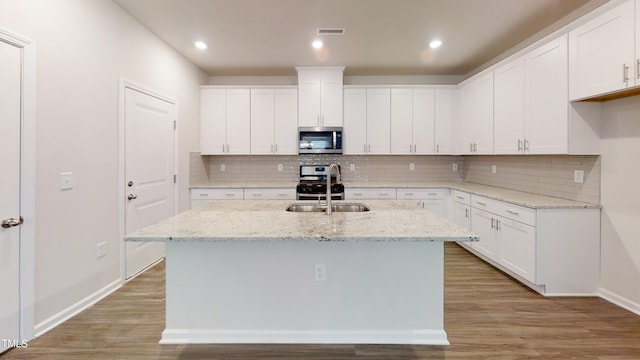 kitchen featuring visible vents, stainless steel appliances, light wood-style floors, and a sink