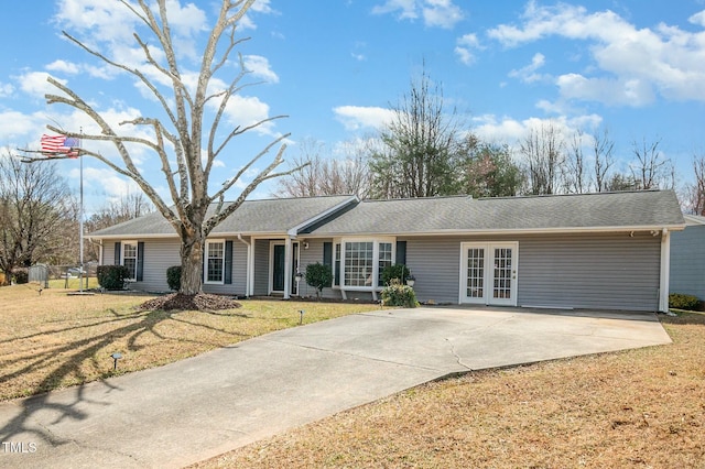 single story home featuring french doors, driveway, and a front lawn