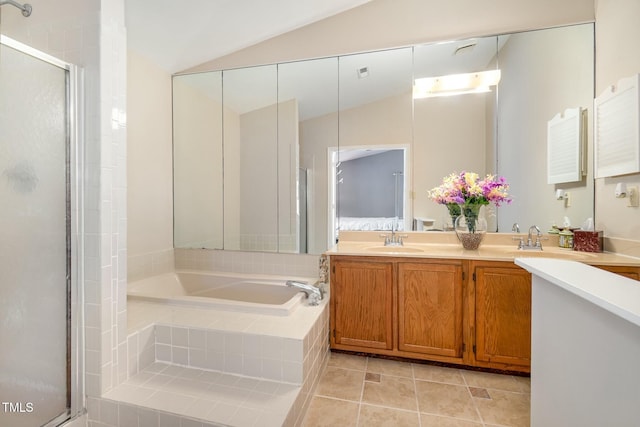 bathroom featuring a bath, vaulted ceiling, a stall shower, and a sink