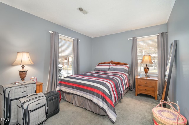 carpeted bedroom with multiple windows and visible vents