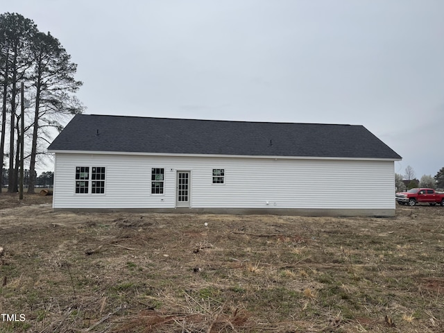 back of house featuring a shingled roof