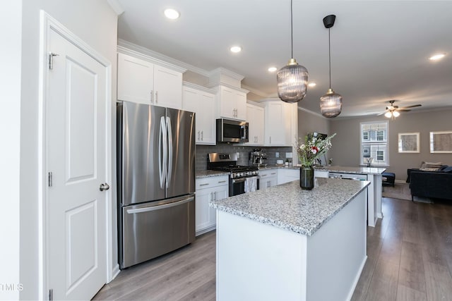 kitchen with open floor plan, light wood-type flooring, a peninsula, white cabinets, and stainless steel appliances