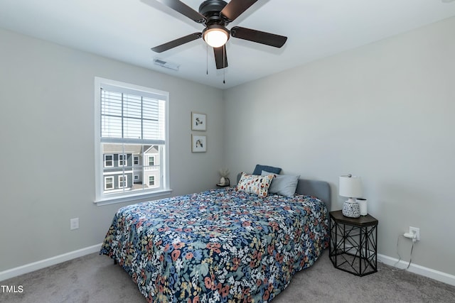 carpeted bedroom with a ceiling fan, visible vents, and baseboards