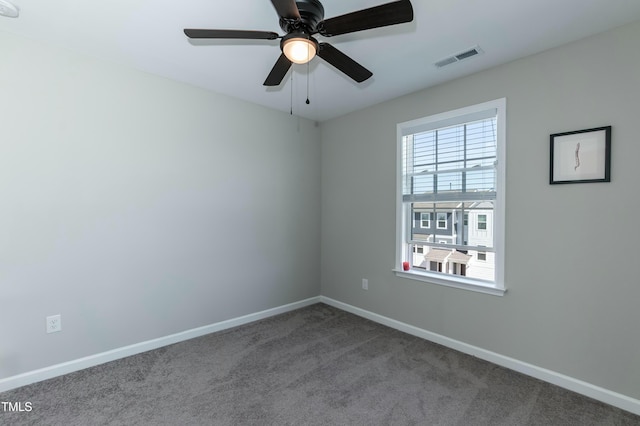 carpeted spare room with visible vents, ceiling fan, and baseboards