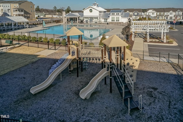 community playground with a patio area, a residential view, a community pool, and fence