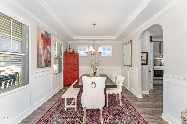 dining space featuring a wainscoted wall, a notable chandelier, dark wood-style floors, and arched walkways