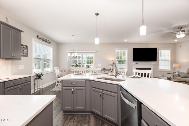 kitchen featuring gray cabinets, a sink, stainless steel dishwasher, open floor plan, and light countertops