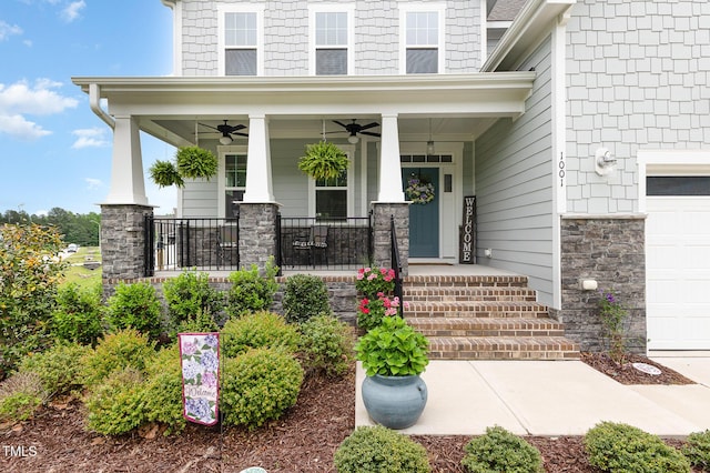 view of exterior entry featuring stone siding, a garage, a porch, and ceiling fan