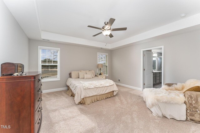 bedroom with baseboards, a raised ceiling, light colored carpet, and visible vents