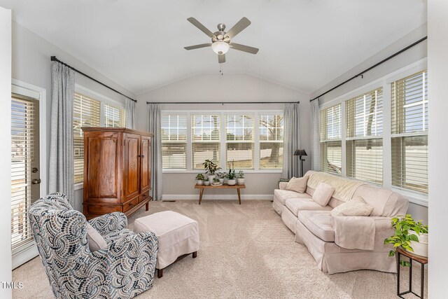 living area featuring light carpet, a healthy amount of sunlight, a ceiling fan, and lofted ceiling