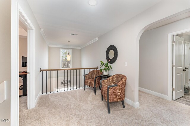 living area with baseboards, visible vents, arched walkways, and carpet floors