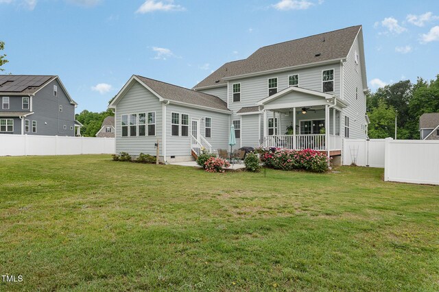 back of house featuring a ceiling fan, a yard, a fenced backyard, and entry steps