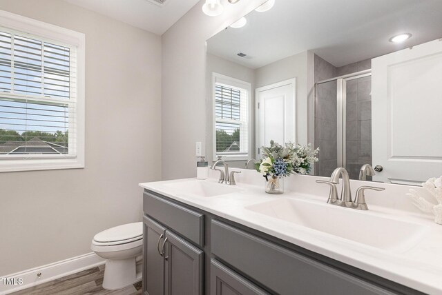 bathroom with a sink, baseboards, toilet, and a shower stall