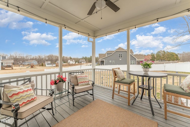 sunroom / solarium featuring a residential view and ceiling fan