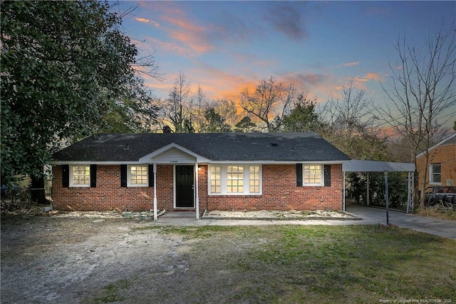 ranch-style house featuring brick siding, driveway, and a lawn