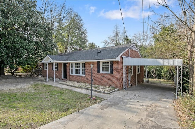 view of front facade featuring brick siding, an attached carport, concrete driveway, a front yard, and roof with shingles