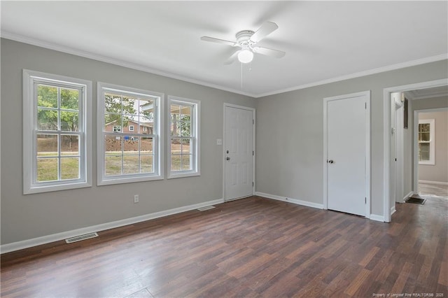 spare room with dark wood finished floors, baseboards, visible vents, and ornamental molding