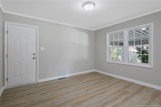 unfurnished room with visible vents, light wood-type flooring, crown molding, and baseboards