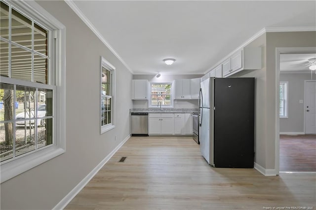 kitchen featuring a sink, stainless steel appliances, crown molding, and white cabinetry