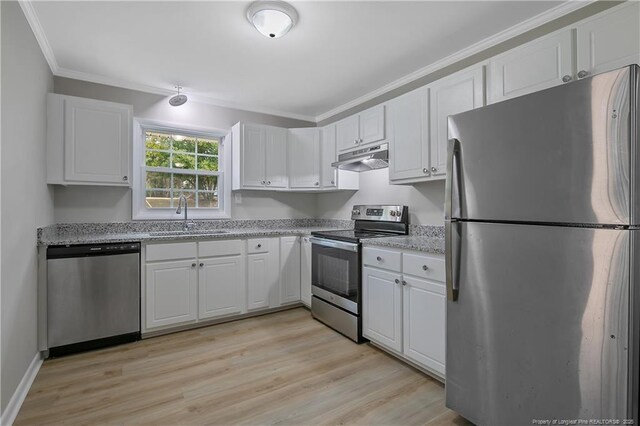 kitchen featuring ornamental molding, a sink, under cabinet range hood, white cabinetry, and stainless steel appliances