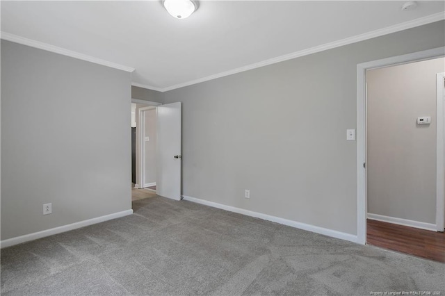 carpeted spare room featuring baseboards and ornamental molding