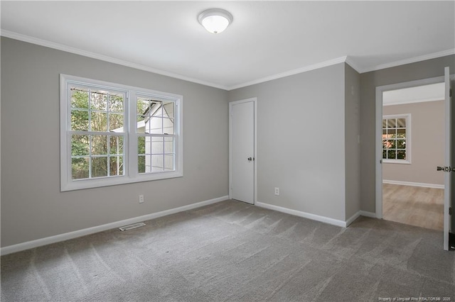 spare room featuring visible vents, baseboards, carpet, and ornamental molding