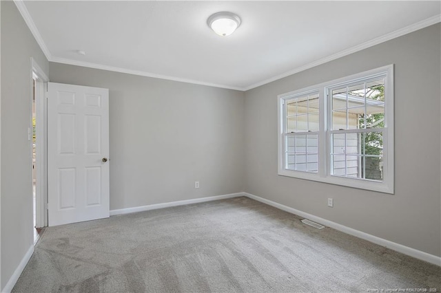 carpeted spare room with crown molding and baseboards