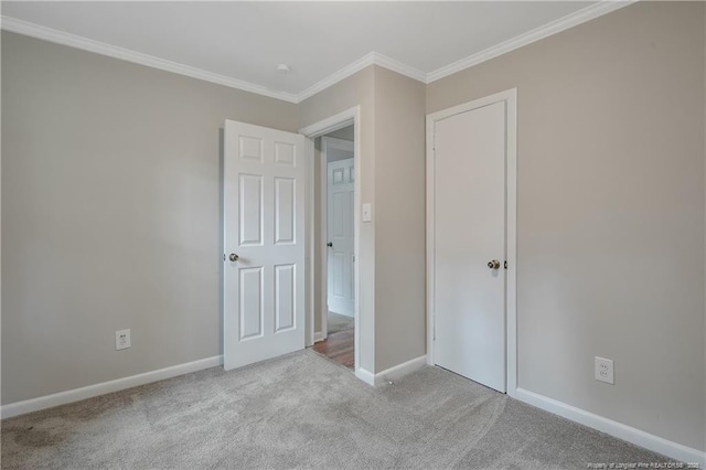 unfurnished bedroom with crown molding, carpet flooring, and baseboards