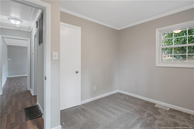 empty room featuring visible vents, attic access, and crown molding