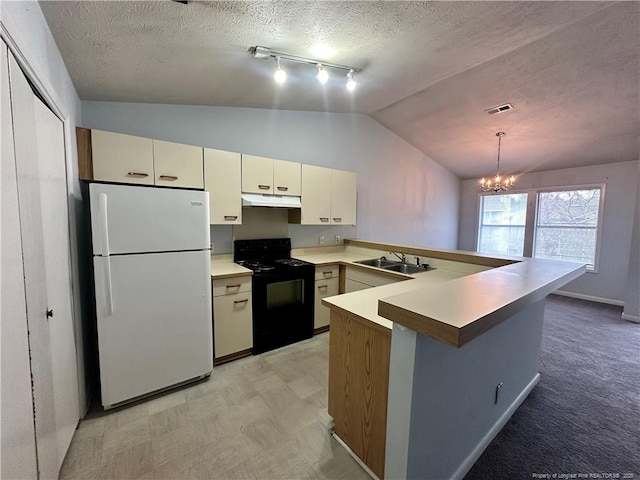 kitchen with under cabinet range hood, a peninsula, freestanding refrigerator, black / electric stove, and a sink