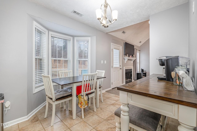 dining area featuring baseboards, lofted ceiling, light tile patterned flooring, a fireplace, and a notable chandelier