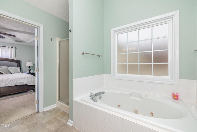 ensuite bathroom with ensuite bathroom, a textured ceiling, a tub with jets, and a shower stall